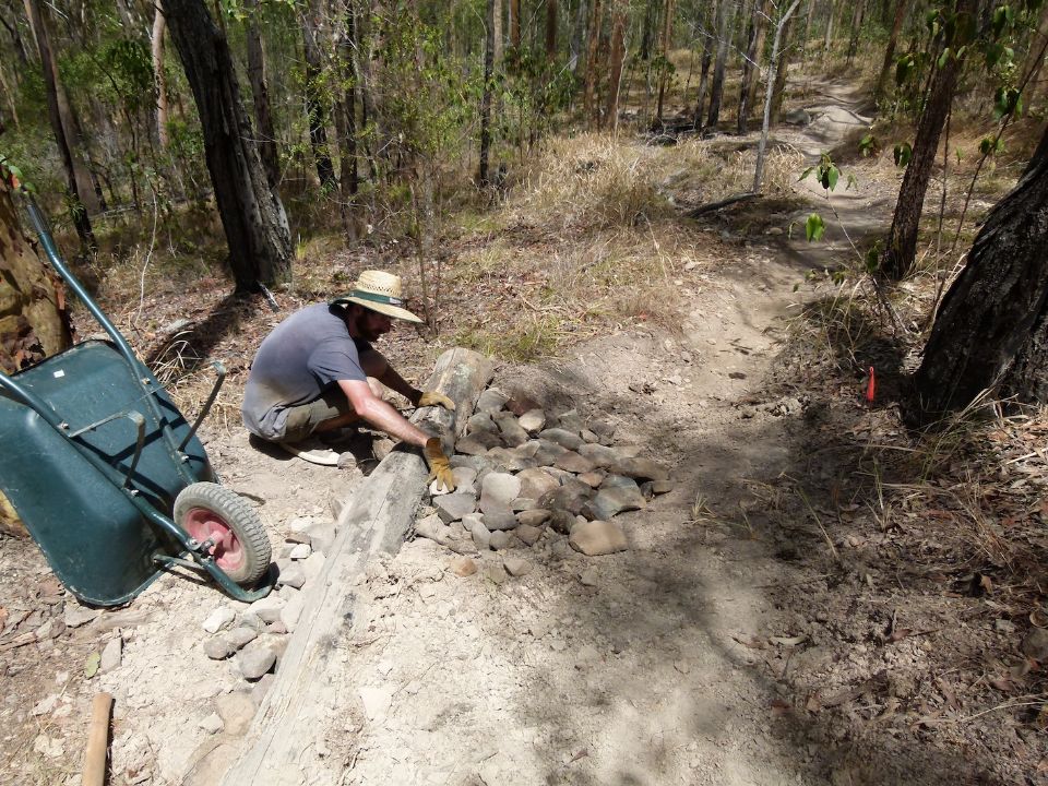 Starting rock fill below a new water bar made of a log and rocks and soil